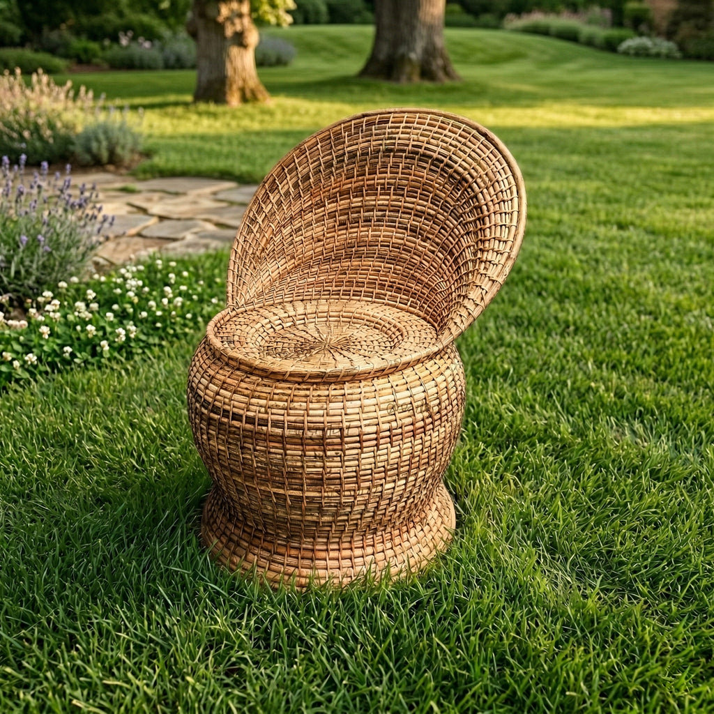 Wicker chair on a grassy lawn with garden in the background