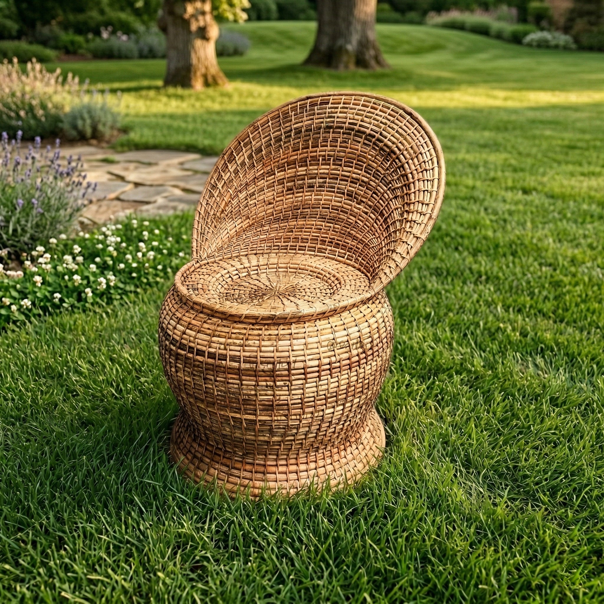 Wicker chair on a grassy lawn with garden in the background