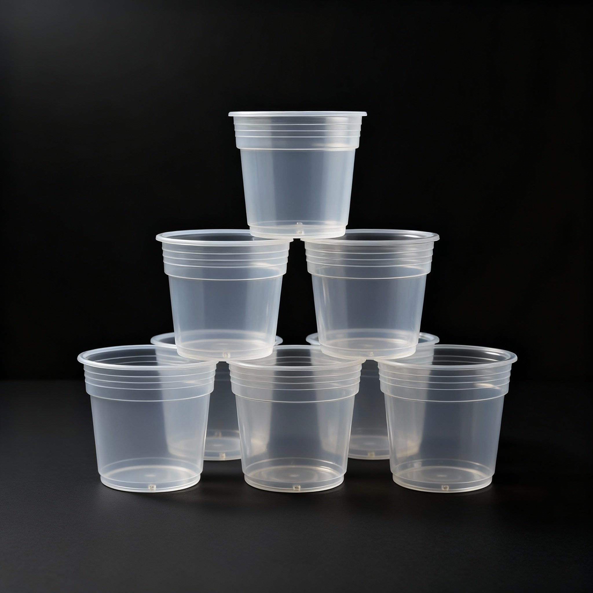 Stack of clear plastic pots on a black background